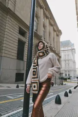 Bufanda tejida a mano en crochet, con capucha y diseño de cuadrados en tonos beige, marrón y negro.