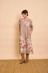 Vestido midi de lino color tostado con estampado floral en tonos rosados y verdes, cuello redondo, mangas cortas y bolsillos laterales.