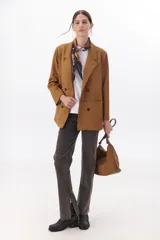 Pantalón de jean gris oscuro, de corte recto, tiro alto y tajos laterales en el ruedo.