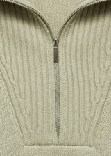 Jersey de punto de lana con cuello alto y cierre de cremallera frontal. Presenta un diseño oversize con mangas largas y terminaciones en canalé.