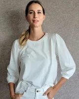 Remera blanca de algodón con cuerpo de jersey y mangas abullonadas de tela tussor al tono. Presenta cuello redondo y puños elásticos.