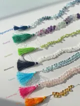 Gargantilla de tanza transparente con dije de piedra semipreciosa en forma de lágrima y separadores dorados.