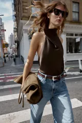 Top blanco satinado con cuello halter y escote fluido. Cierre en la espalda con botones.