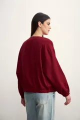 Chaqueta tipo bomber color negro, con cierre frontal metálico, cuello redondo y puños elásticos.