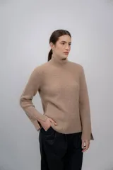 Polera gris de tejido de punto grueso, con cuello alto y mangas largas.