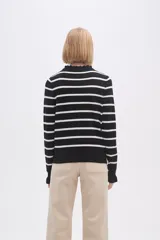 Sweater de punto a rayas horizontales negras y blancas, con cuello en V adornado con pequeños volados y mangas largas.