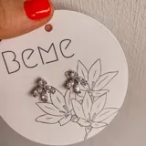 Par de aros plateados con forma de copo de nieve, con incrustaciones de circonitas transparentes. Cierre a presión.