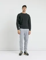 Sweater de punto en color negro, con cuello redondo, mangas largas y puños acanalados.