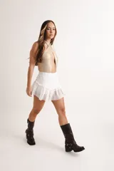 Body dorado brillante con escote halter cruzado y abertura en el abdomen.