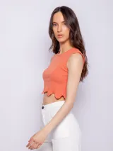 Top color salmón sin mangas, con cuello redondo y terminación ondulada en el ruedo.