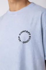Remera verde militar de algodón con efecto lavado gastado y corte oversize. Estampa circular blanca con texto "VCP CONCEPT STUDIO" en el frente.