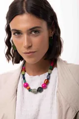 Collar corto compuesto por cuentas de diversos materiales, incluyendo piedras naturales, cristales, madera y acrílico en una variedad de colores y formas. Cuenta con un cierre de cadena de acero quirúrgico ajustable.