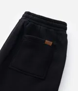 Pantalón de corte recto confeccionado en tejido de algodón, con cintura elástica ajustable mediante lazo y bolsillos laterales.