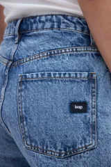 Short de jean celeste, tiro medio, levemente ajustado en la cadera y con bajo desflecado.