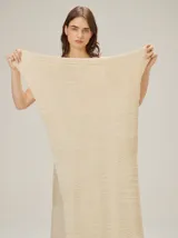Chal de punto color beige con textura acanalada y sutil brillo metalizado.