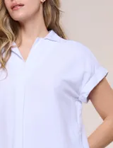 Blusa blanca de algodón y viscosa, con cuello camisero, escote en V y mangas cortas con vuelta.