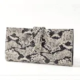 Billetera grande con estampado de víbora en tonos blanco y negro, con cierre de broche a presión. En su interior tiene doble compartimento con cierre, bolsillo y tarjetero.
