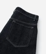 Pantalón de jean estilo baggy balloon, de corte holgado con volumen en las piernas y cintura fija con trabillas. Presenta costuras a contratono y detalle de cadena metálica lateral.