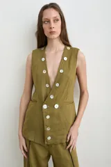 Chaleco de lino color verde militar, con escote en V profundo, sin mangas y cierre frontal cruzado con doble botonadura de nácar.