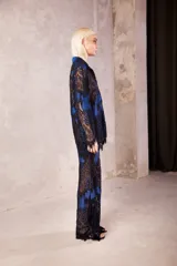 Pantalón de encaje con diseño de flores en color negro sobre base azul, de tiro medio con cintura elástica y corte oxford acampanado.
