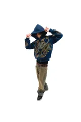 Hoodie azul con cierre y bolsillos laterales, con estampado dorado de hojas de acanto en el frente y las mangas.