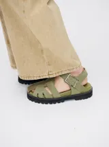 Sandalias romanas de cuero tostado, estilo chunky con plataforma y suela tractora de goma negra. Cuentan con tiras cruzadas en el empeine y tira ajustable con hebilla metálica en el tobillo.