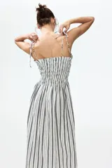 Vestido midi de mezcla de viscosa, con estampado de rayas verticales en blanco y negro, escote recto, cuerpo fruncido tipo nido de abejas, breteles finos con lazo y falda con vuelo.