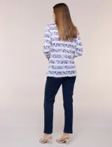 Remera confeccionada en algodón liviano de silueta semi entallada, con escote en V y mangas tres cuartos. Presenta un diseño estampado que combina franjas florales en tonos violeta y rayas chevron, con un nudo decorativo en el ruedo frontal.