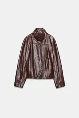 Chaqueta de efecto piel en color marrón de la colección Zara Woman Collection. Presenta cuello alto, cierre frontal cruzado con cremallera metálica, bolsillos ocultos en costura y manga larga.