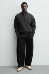 Zapatilla deportiva de estilo retro con diseño de paneles combinados en tonos beige y crema. Presenta detalles en gamuza y una suela de goma en color caramelo.