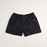 Bóxer de algodón blanco con estampado de flores pequeñas color celeste, con cintura elástica y logo de la marca en el centro.