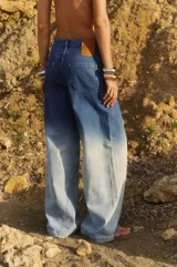 Jean de tiro medio, corte oversize y pierna ancha, con efecto degradado de azul oscuro a celeste claro. Confeccionado en denim 100% algodón, presenta badana de PU y avíos metálicos.