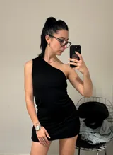 Vestido corto negro de un solo hombro, ajustado al cuerpo.
