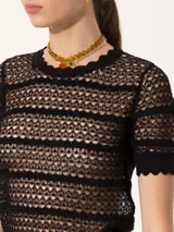 Top de tejido crochet color beige, con cuello redondo y mangas cortas con terminación ondulada.