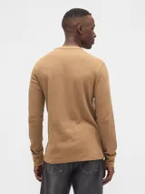 Remera de manga larga con textura tipo waffle, cuello redondo y puños acanalados.