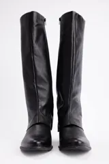 Bota de caña alta confeccionada en cuero vacuno, con diseño de solapa superior y taco bajo cuadrado.