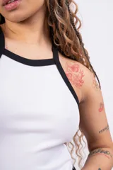 Top de rib con lycra, de corte ajustado y diseño sin mangas con cuello redondo y ribetes en contraste color negro.