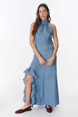 Vestido midi de lino color celeste, con escote halter alto y detalle de volados en el bajo.