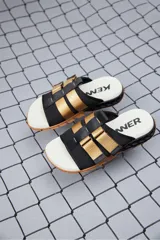 Sandalias Kenner Rakka Yaki con base color hueso, suela marrón y tiras de tela negra con apliques de cuero sintético color beige.