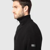 Sweater de punto grueso color negro, con cuello alto y cierre frontal parcial metálico. Presenta puños y ruedo acanalados, con un diseño de calce holgado.