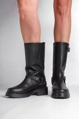 Borcego de cuero negro con apliques plateados y caña alta.