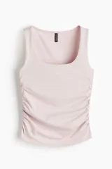 Musculosa ajustada color rosa pálido con escote cuadrado y frunces laterales que generan un efecto drapeado.