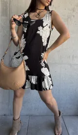 Vestido corto negro con estampado floral blanco, de corte suelto y sin mangas.