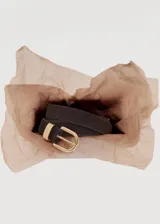 Cinturón de gamuza color gris oscuro con hebilla y pasador metálicos dorados.
