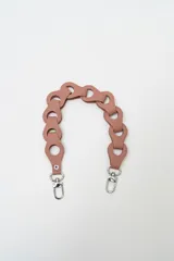 Correa para cartera de cuero sintético color rosado, con diseño entrelazado de argollas y mosquetones metálicos plateados en los extremos.
