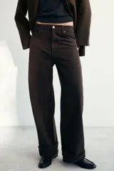Jeans de tiro medio con corte baggy y pierna relajada. Presenta diseño de cinco bolsillos, cierre frontal con cremallera y botón, y bajo acabado con vuelta.