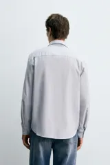 Camisa de corte regular fit confeccionada en una mezcla de algodón y lana. Presenta cuello solapa, manga larga con puños abotonados y cierre frontal con botonadura.