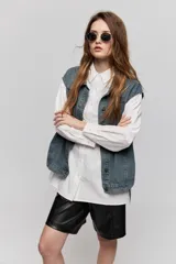 Camisa de algodón blanca de calce relajado, con cuello clásico, mangas largas y cierre frontal con botones.