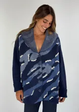 Saco de lana con estampado abstracto en tonos azules y blanco, cuello tipo chal y cierre frontal con botones.