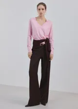 Chaleco de punto fino color rosado, con diseño recto, cuello en V y mangas largas.
